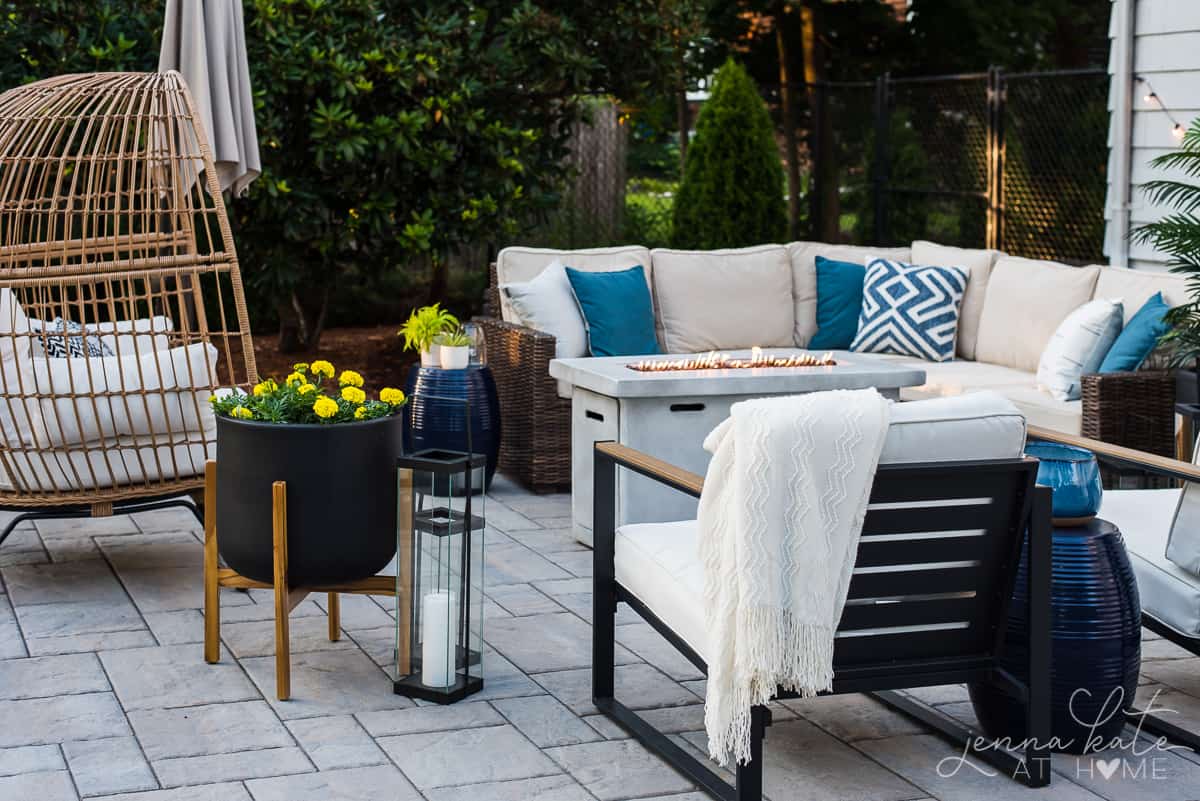 A coastal inspired seating area with woven wicker furniture and blue and white throw pillows