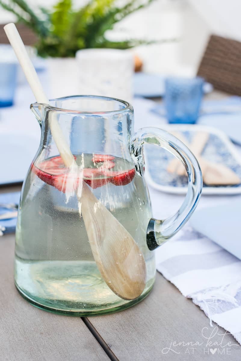 A crystal pitcher filled with fruit water flavored with fresh strawberries