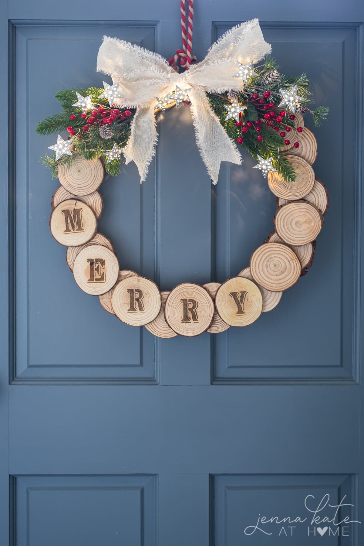 Wood slice DIY holiday wreath hung on a blue door