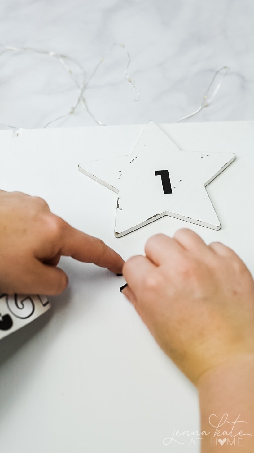 A white wooden star used for the top of the Advent Calendar tree with a black number one sticker.