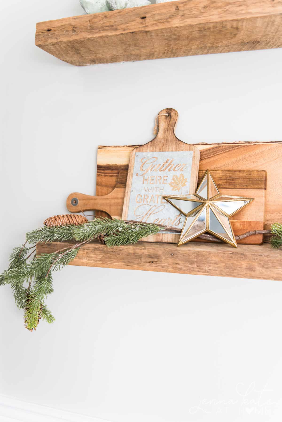 Kitchen shelves with Christmas decor, wooden cutting boards and greenery