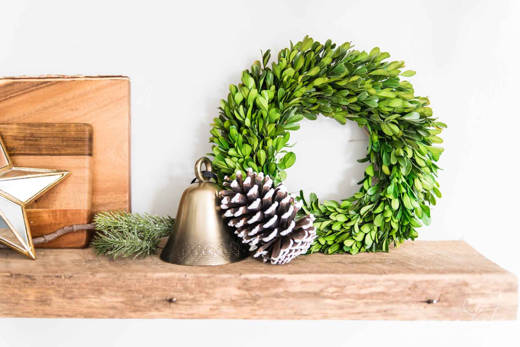 Small boxwood wreath, bell and a large pinecone