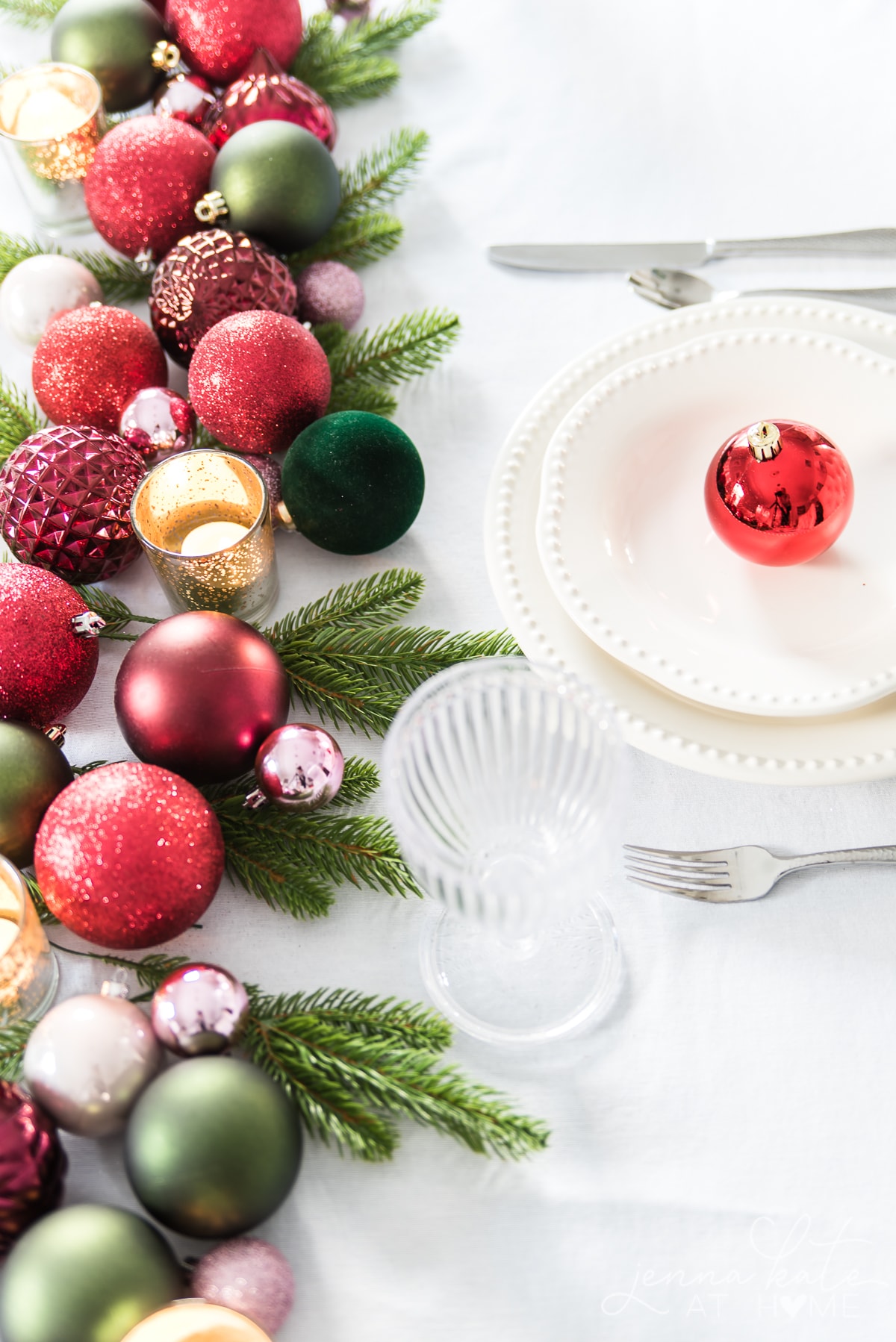 ornament runner with white plates with red ornaments in the center