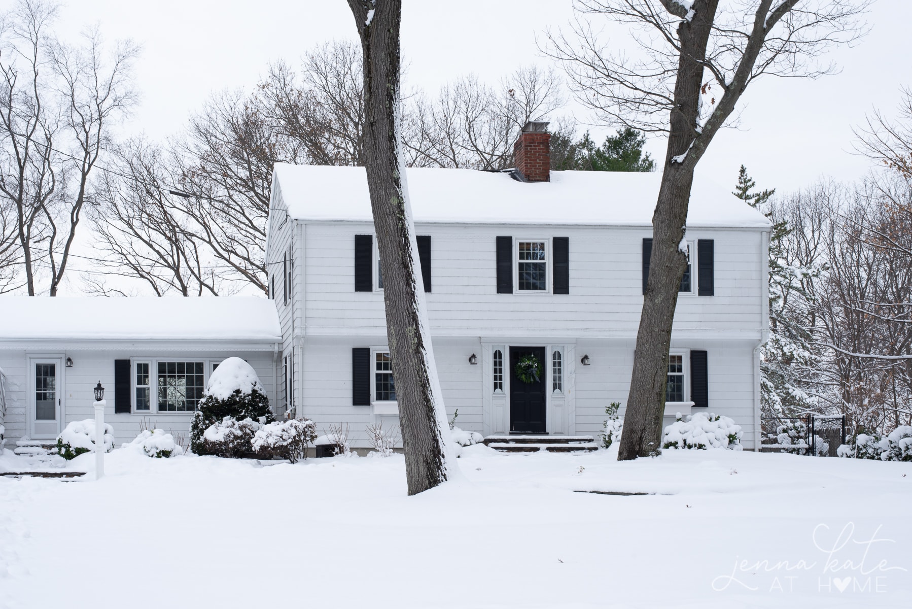 White Colonial house covered in snow