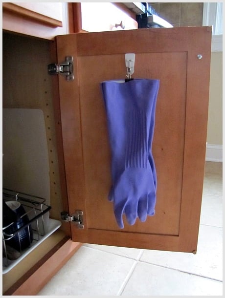 Binder clip on back of cabinet to hang rubber gloves is a great way to do small space organization