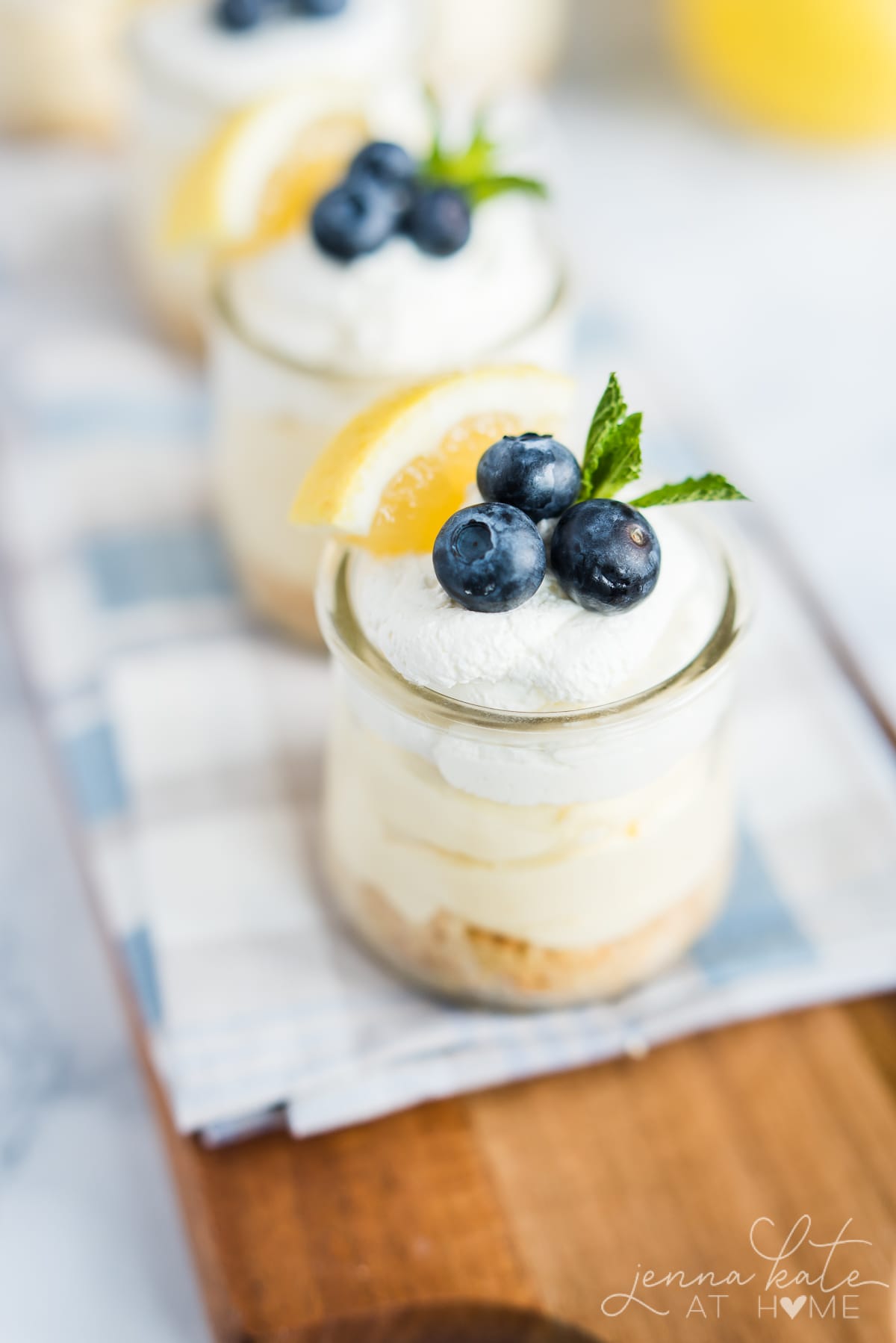 Closeup of freshly whipped cream and toppings on the lemon cheesecakes in jars
