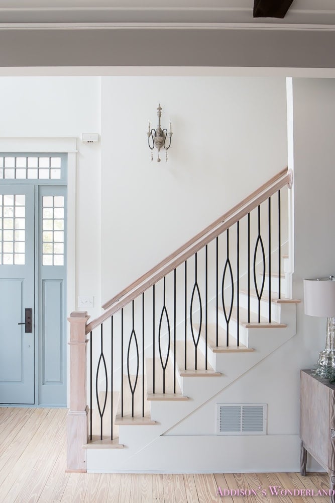 light and bright foyer painted white with bleached wood handrails and floors