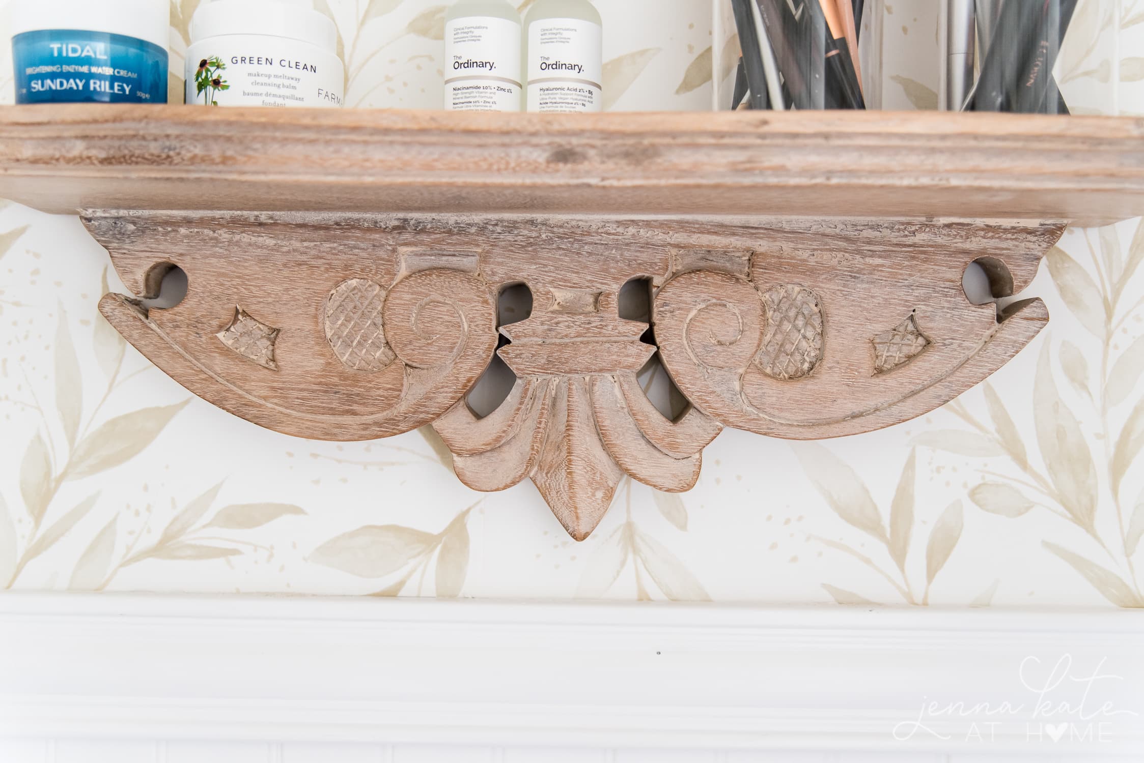 Closeup of carved details on the natural wood bathroom shelf