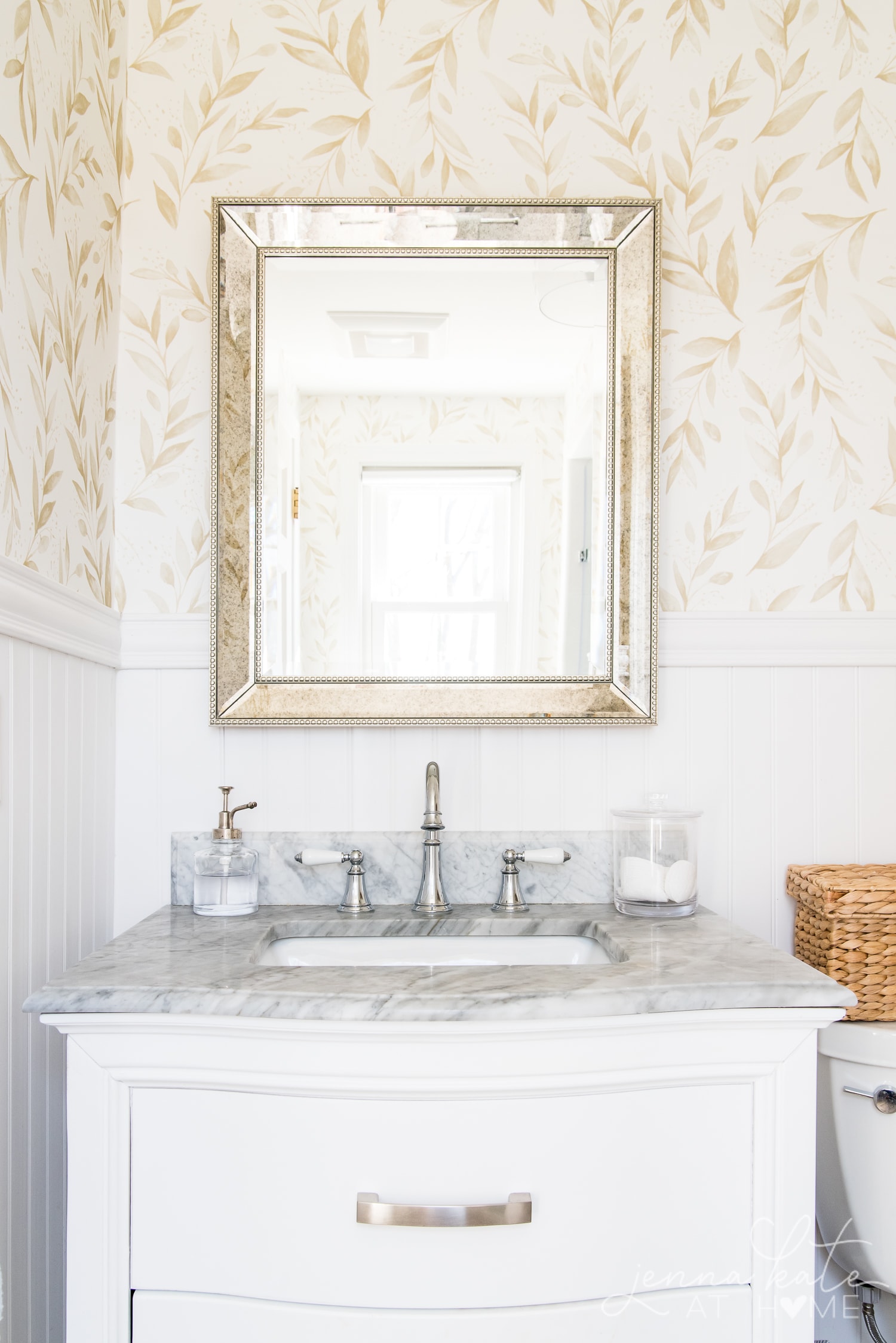 Elegant bathroom with floral wallpaper, chrome hardware and white vanity