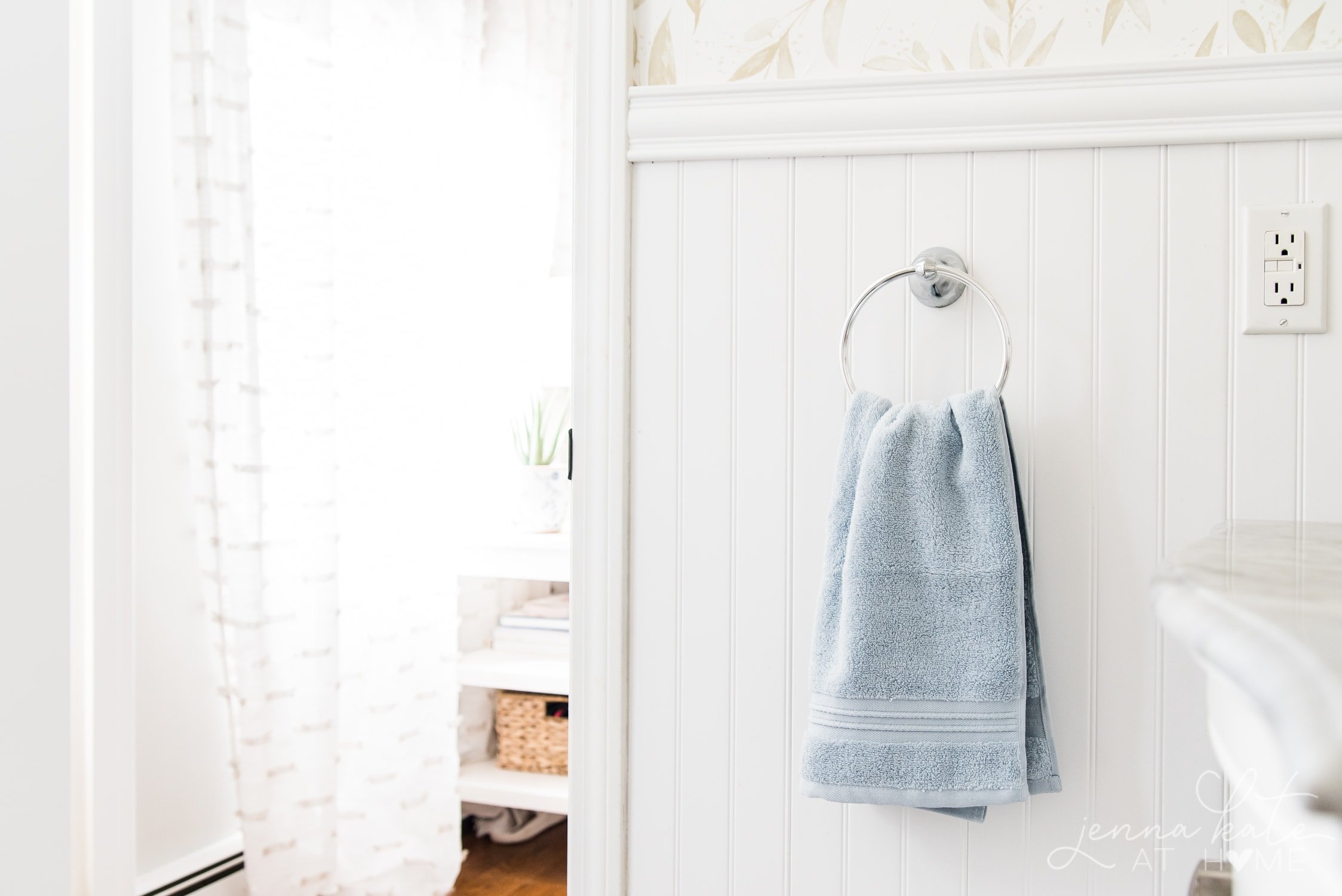Powder blue towel hanging against white bead board in master bathroom