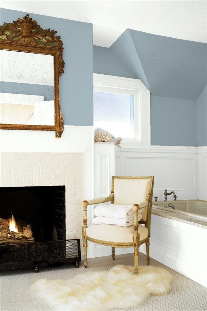 Santorini Blue bedroom paired with white wainscoting brings out the blue in this blue-gray paint color