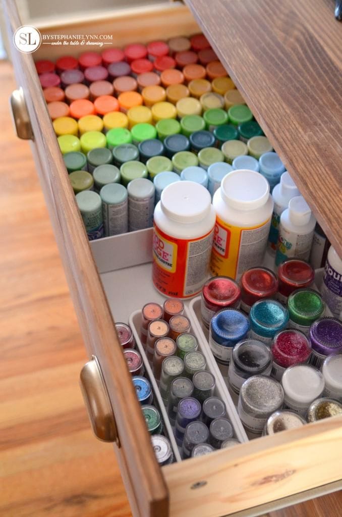 Craft room drawer organized with paint, glue and glitter supplies