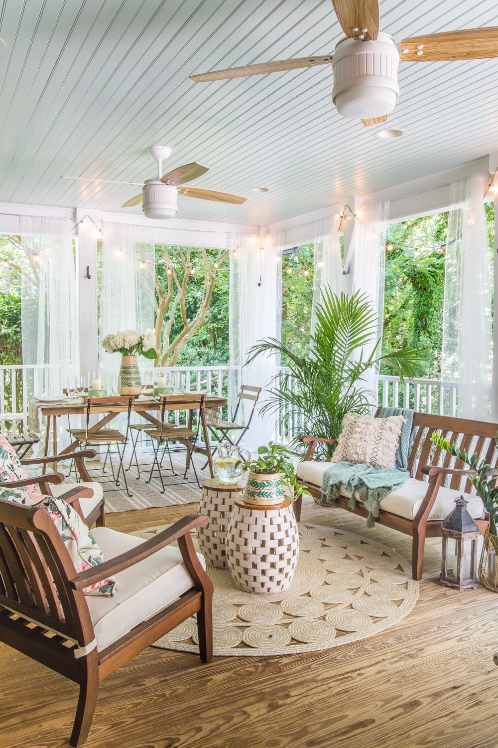 Boho style back porch with curtains and ceiling fans