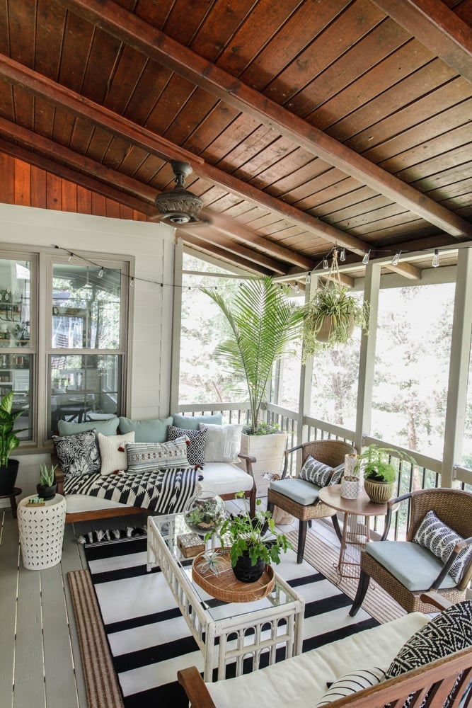 Screened in porch with dark wood ceilings and boho style decor