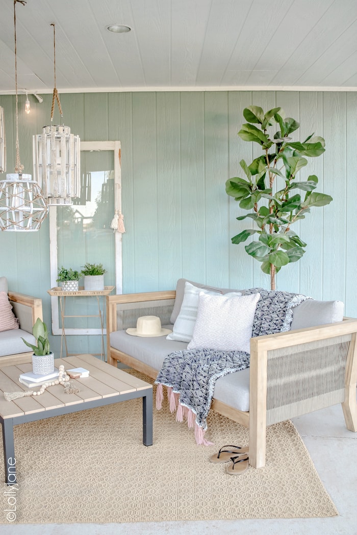 Coastal farmhouse style porch with neutral furniture and seafoam green walls