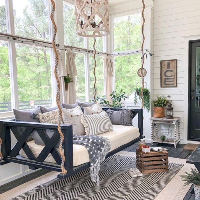 Daybed hanging from the ceiling of a  porch