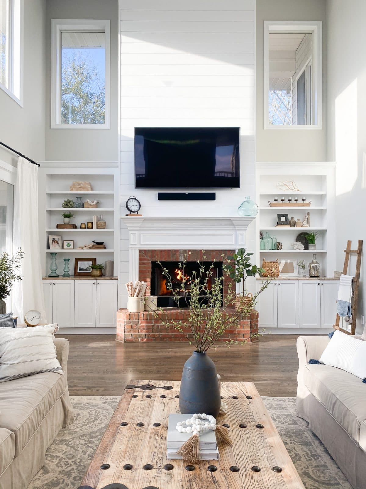 two story living room with fireplace and built ins and the walls painted Repose Gray