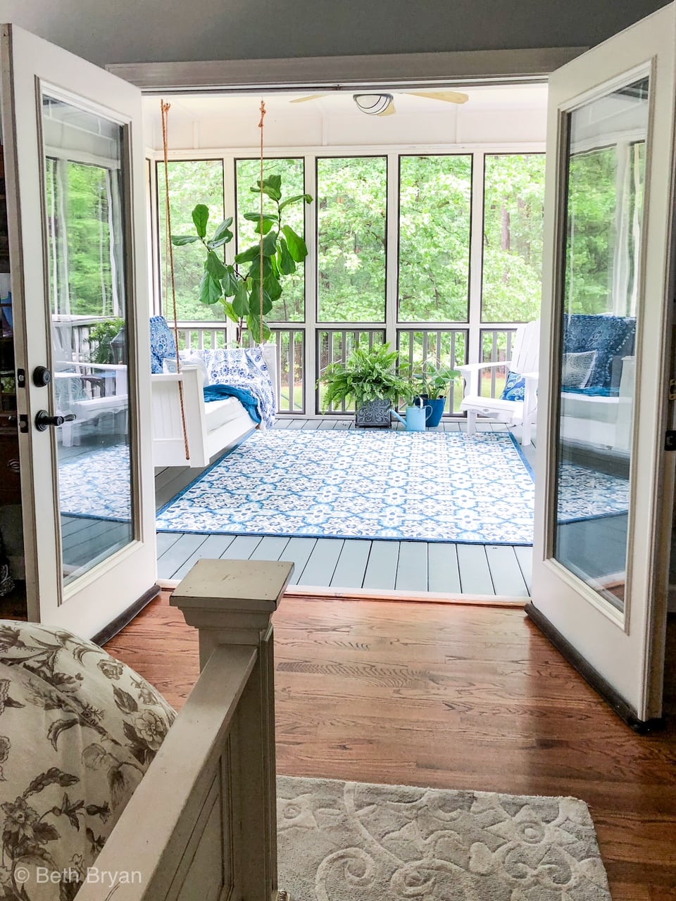 Blue and white porch decor with hanging swing and adirondack chairs