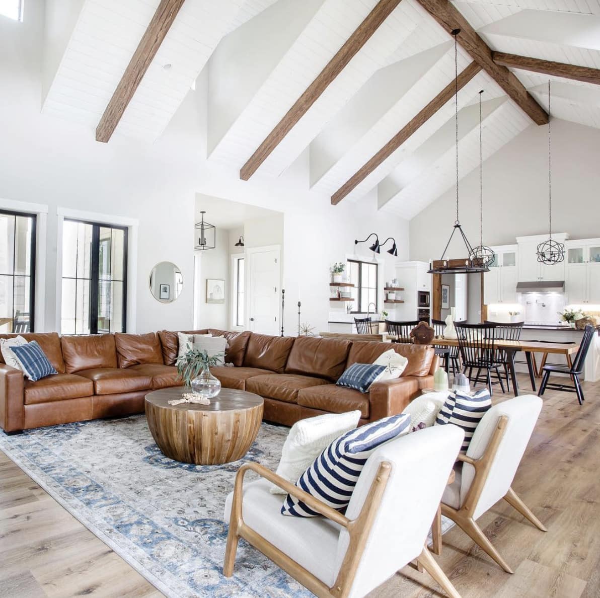 modern farmhouse-style great room with large living room rug placed under the sectional sofa and armchairs