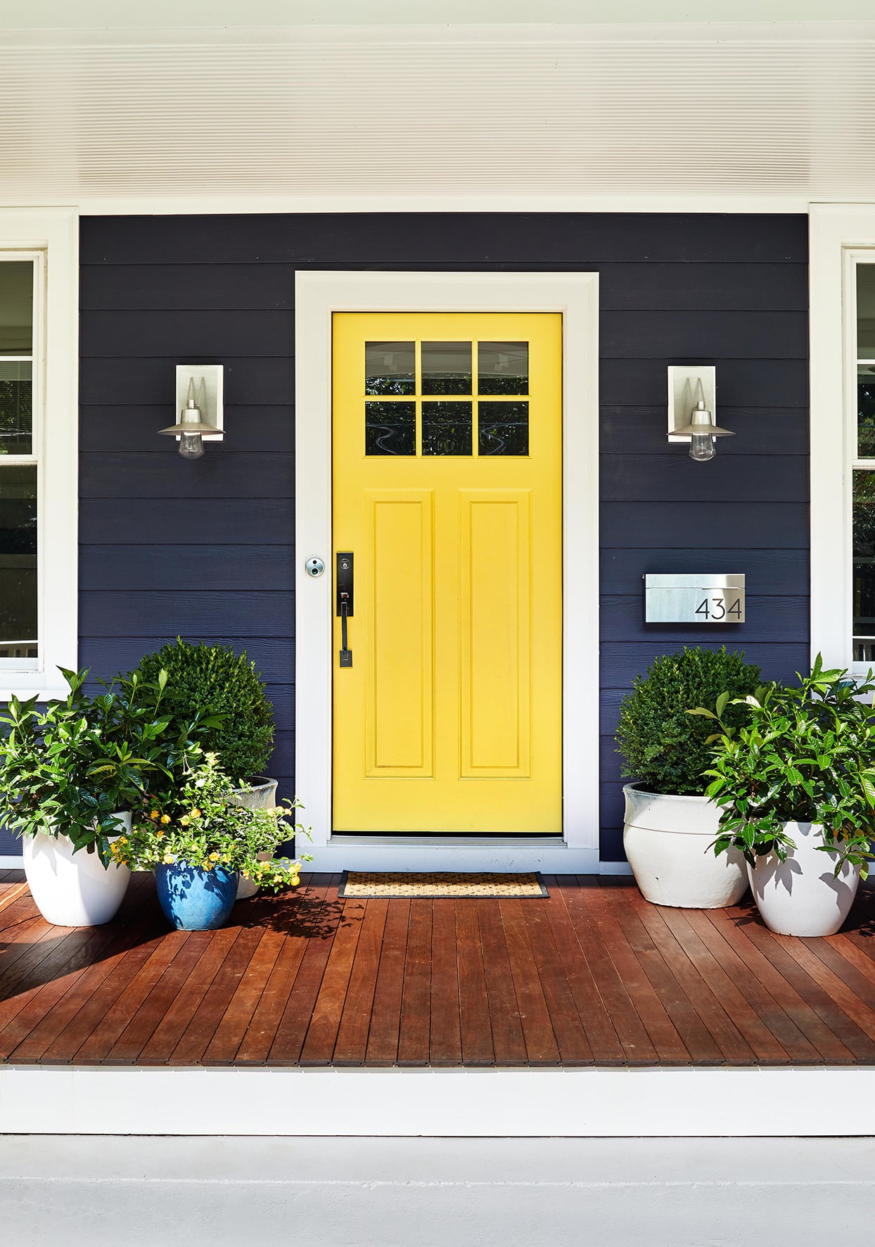 A house with navy side and a bright yellow door