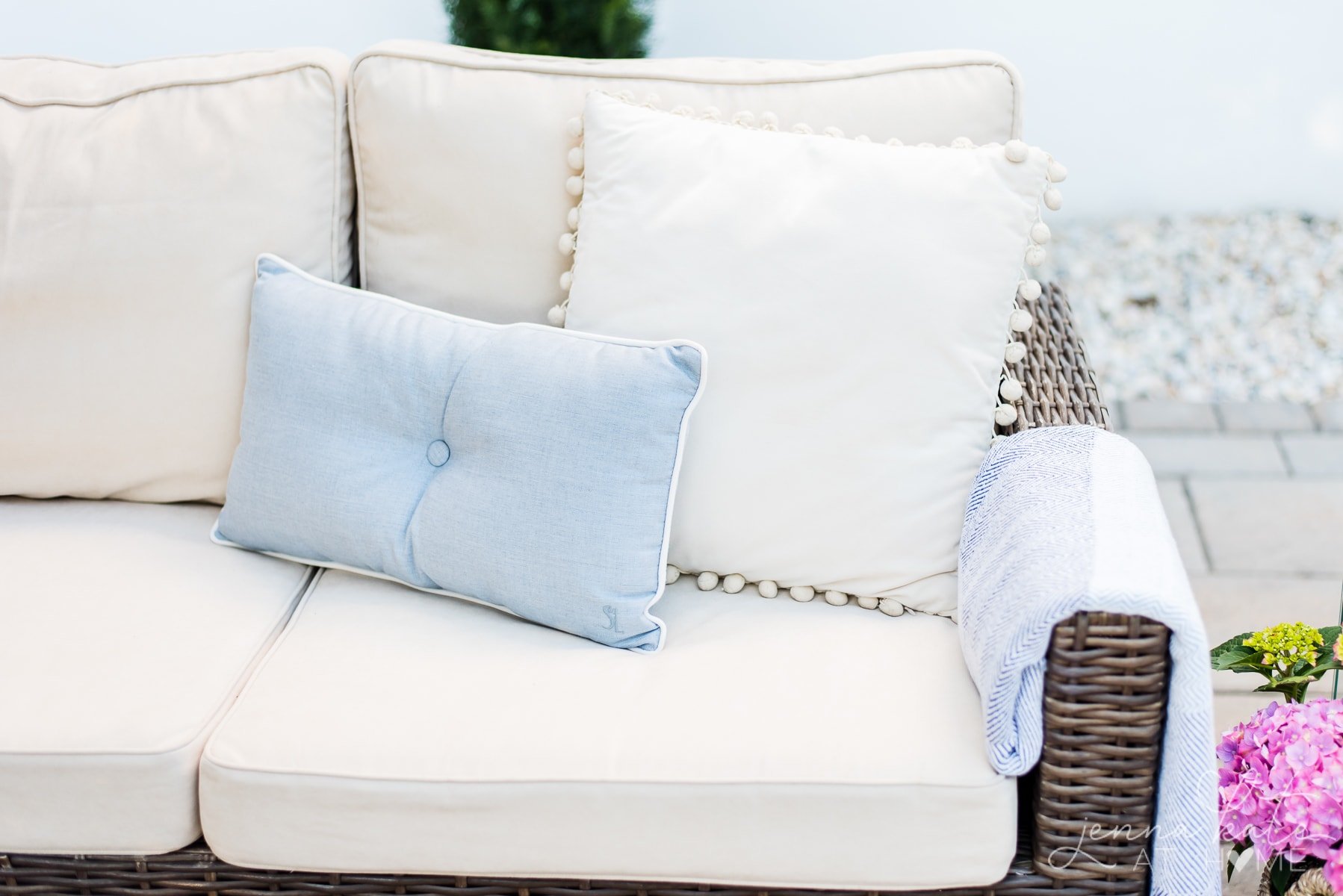 Clean patio cushions back on the fiurniture with a blue accent pillow