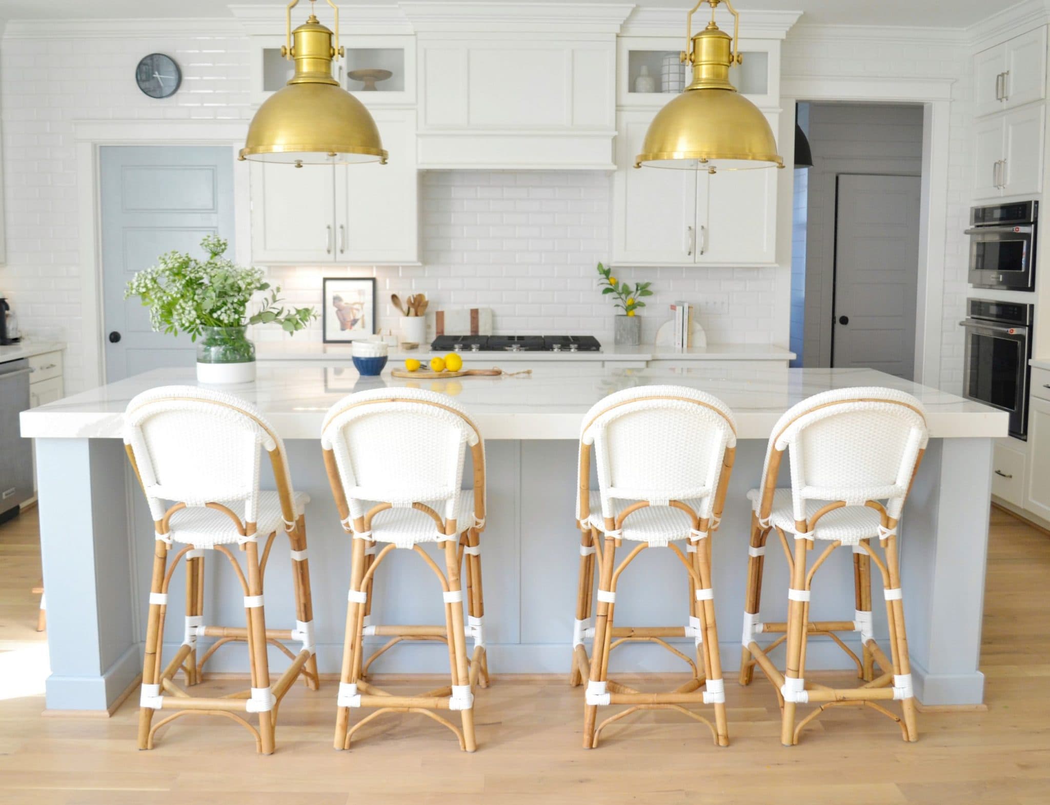 kitchen island painted sherwin williams krypton with white island chairs and polished brass pendant lights overhead