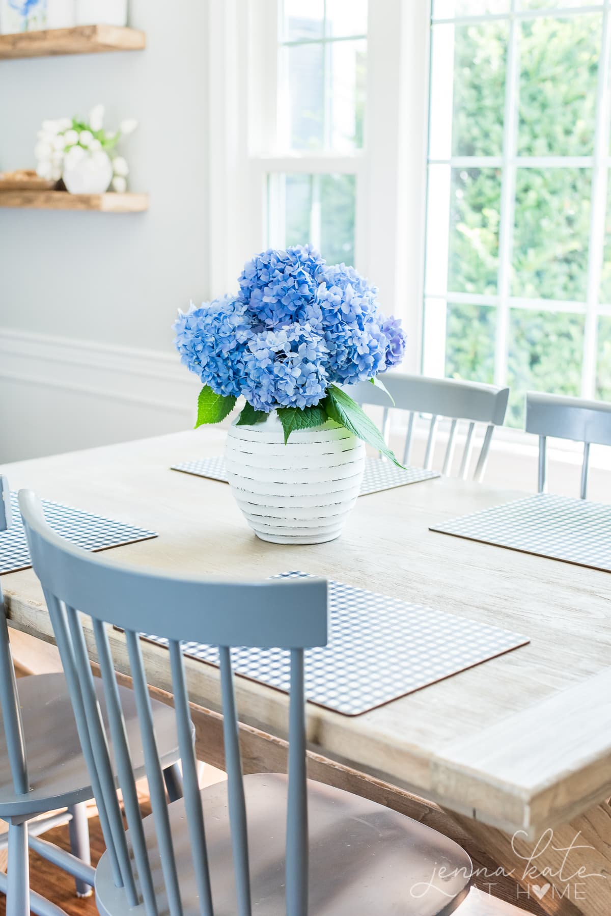 kitchen table in summer with a vase of blue hydrangeas 