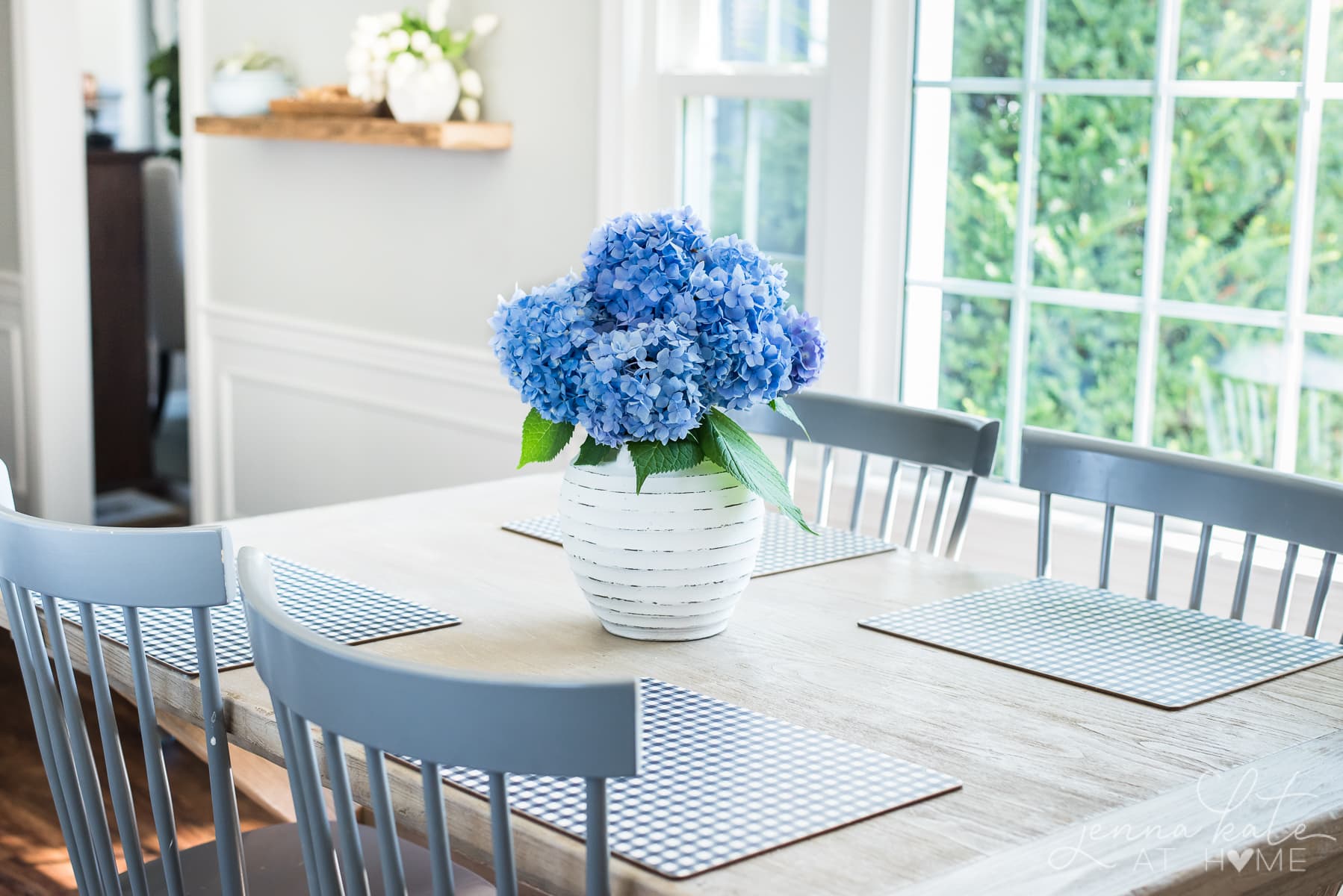 white vase of fresh cut hydrangeas on a kitchen table