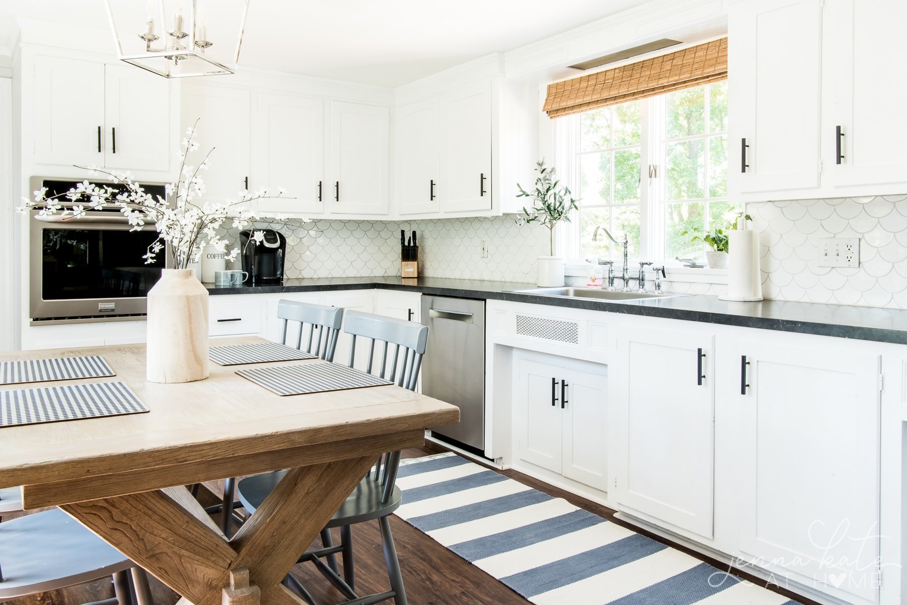 Kitchen with flat black kitchen hardware, striped runner rug and table