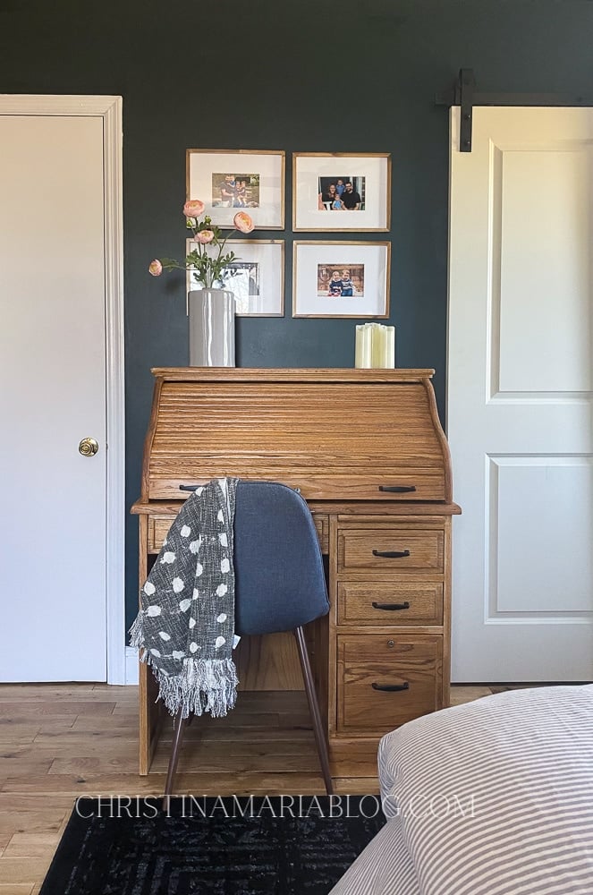 Dark green walls with oak desk in front of them