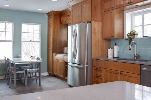 Honey oak kitchen cabinets with a soft blue green paint color on the walls