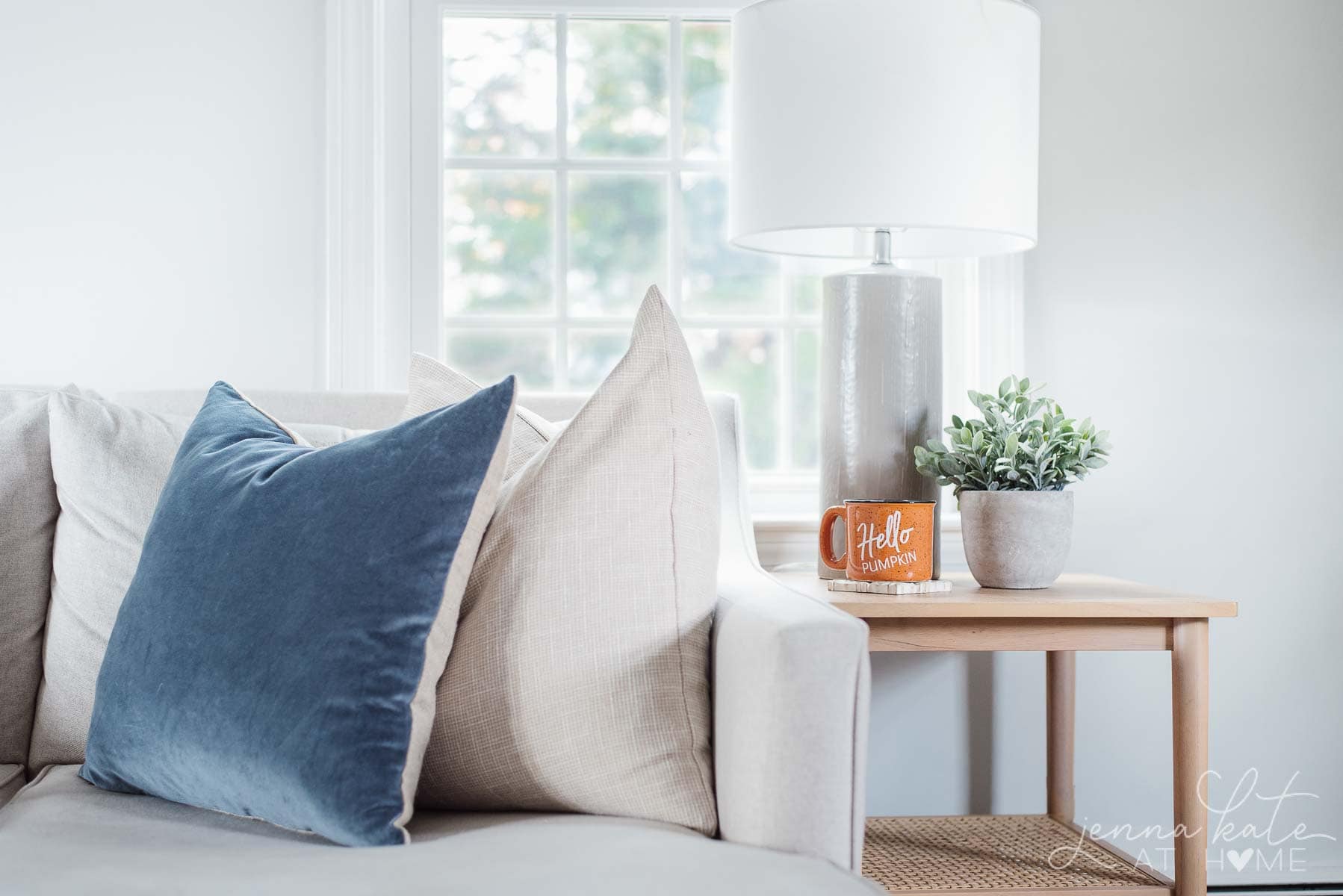 two pillows resting on the end of a couch with a coffee table beside it.