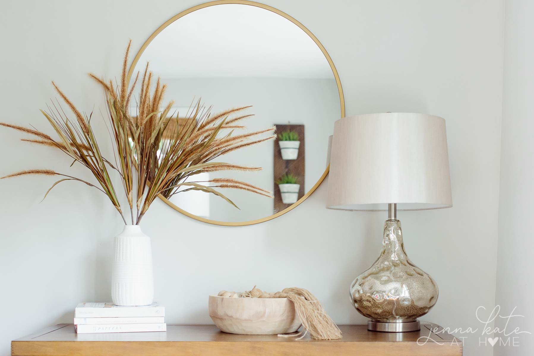 simple fall vignette with dried grass in a vase, a bowl with wooden beads and a mercury glass lamp