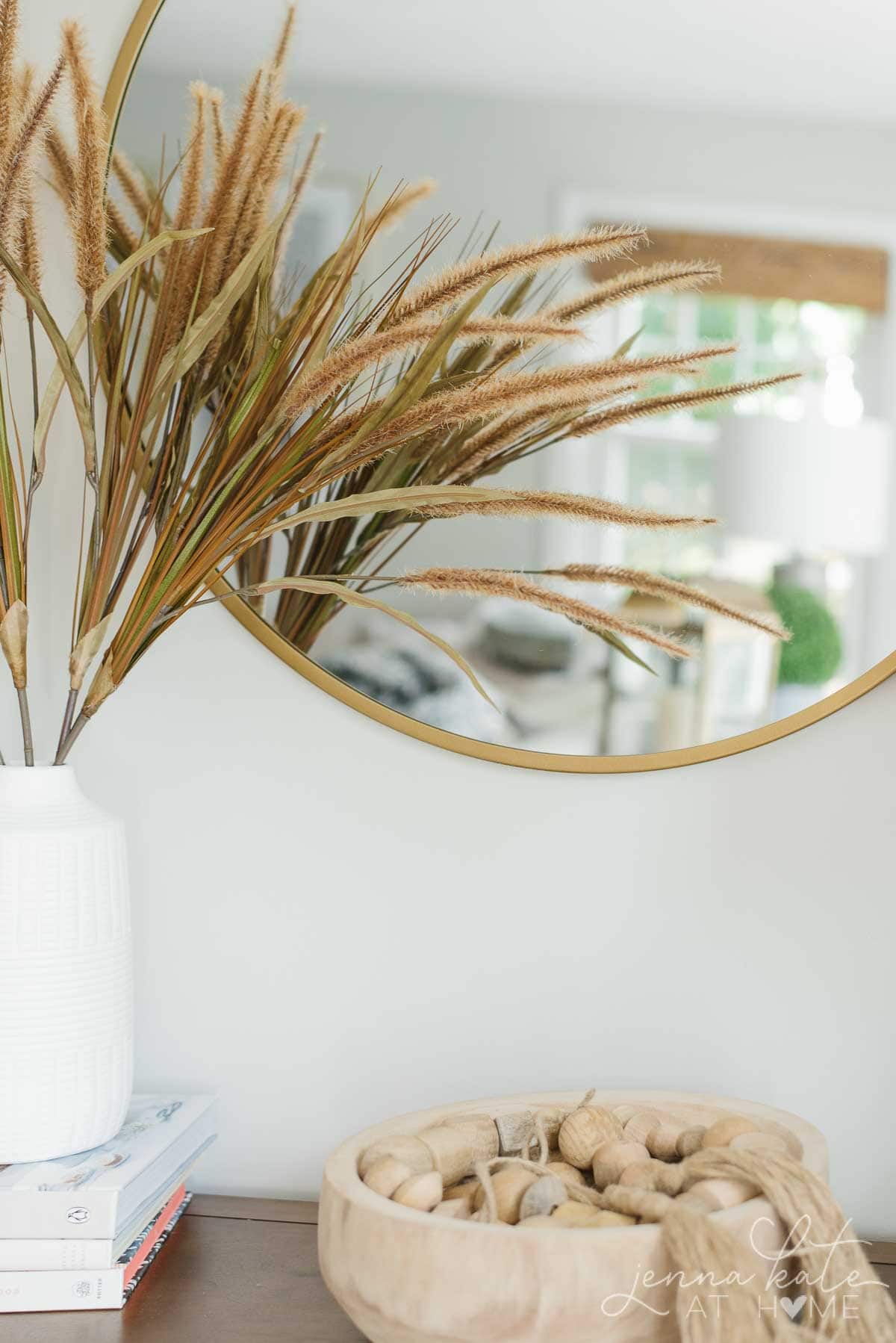 console table with mirror and dried grasses