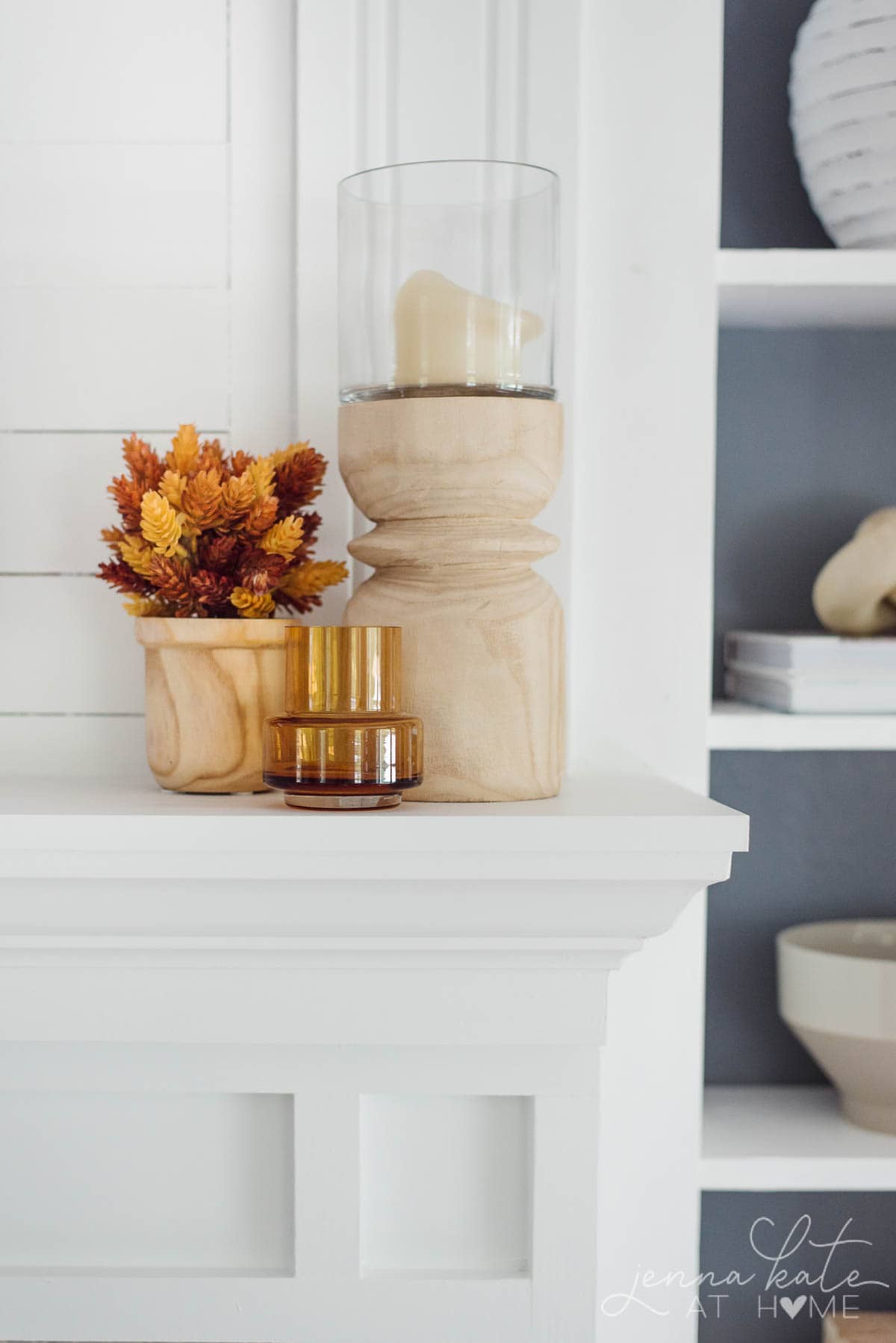 wooden candle holder, faux fall flowers and amber glass on a mantel