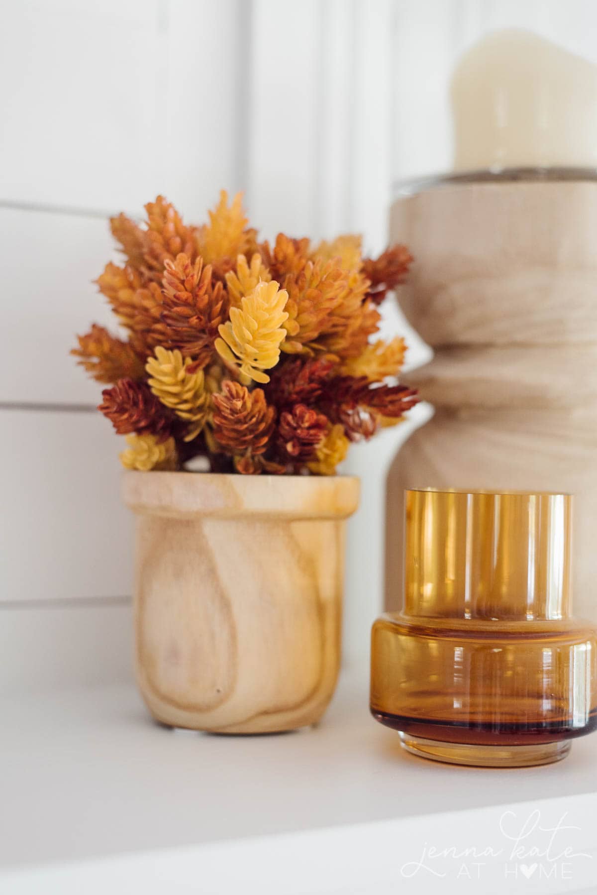 Amber glass and faux fall plant on the mantel