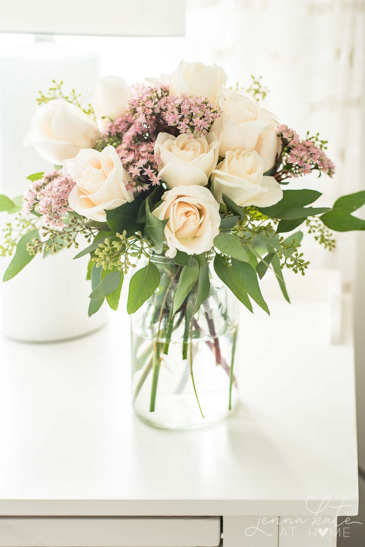 bouquet of roses, sedum and eucalyptus on bedroom nightstand