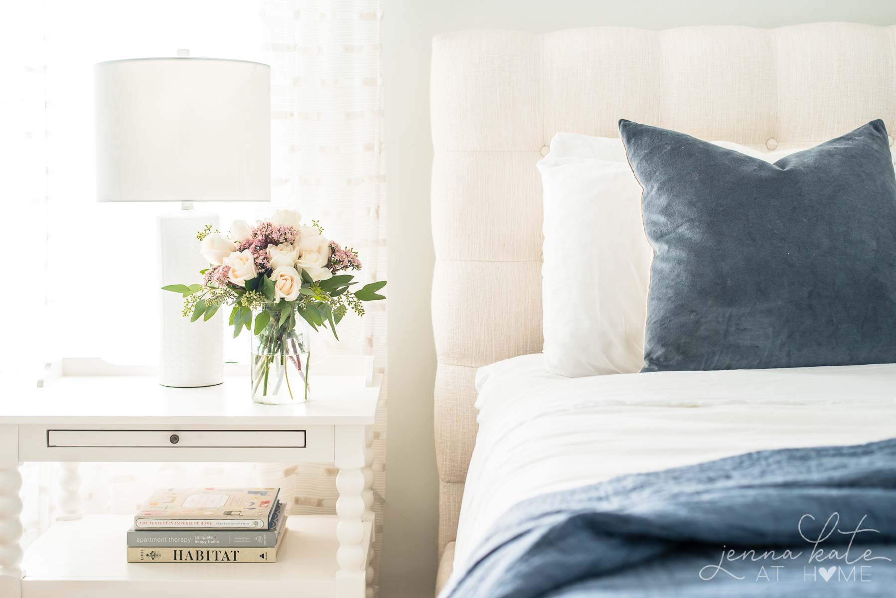 bed with fall flowers on the nightstand next to it