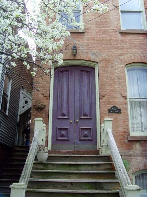 plum front door on red brick house