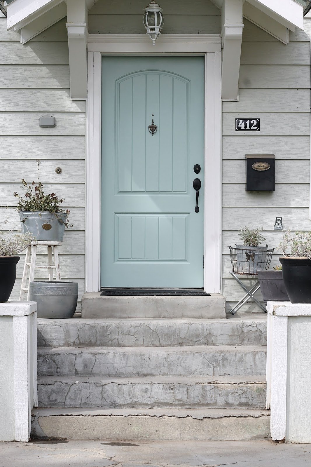 sage green house with yellow door