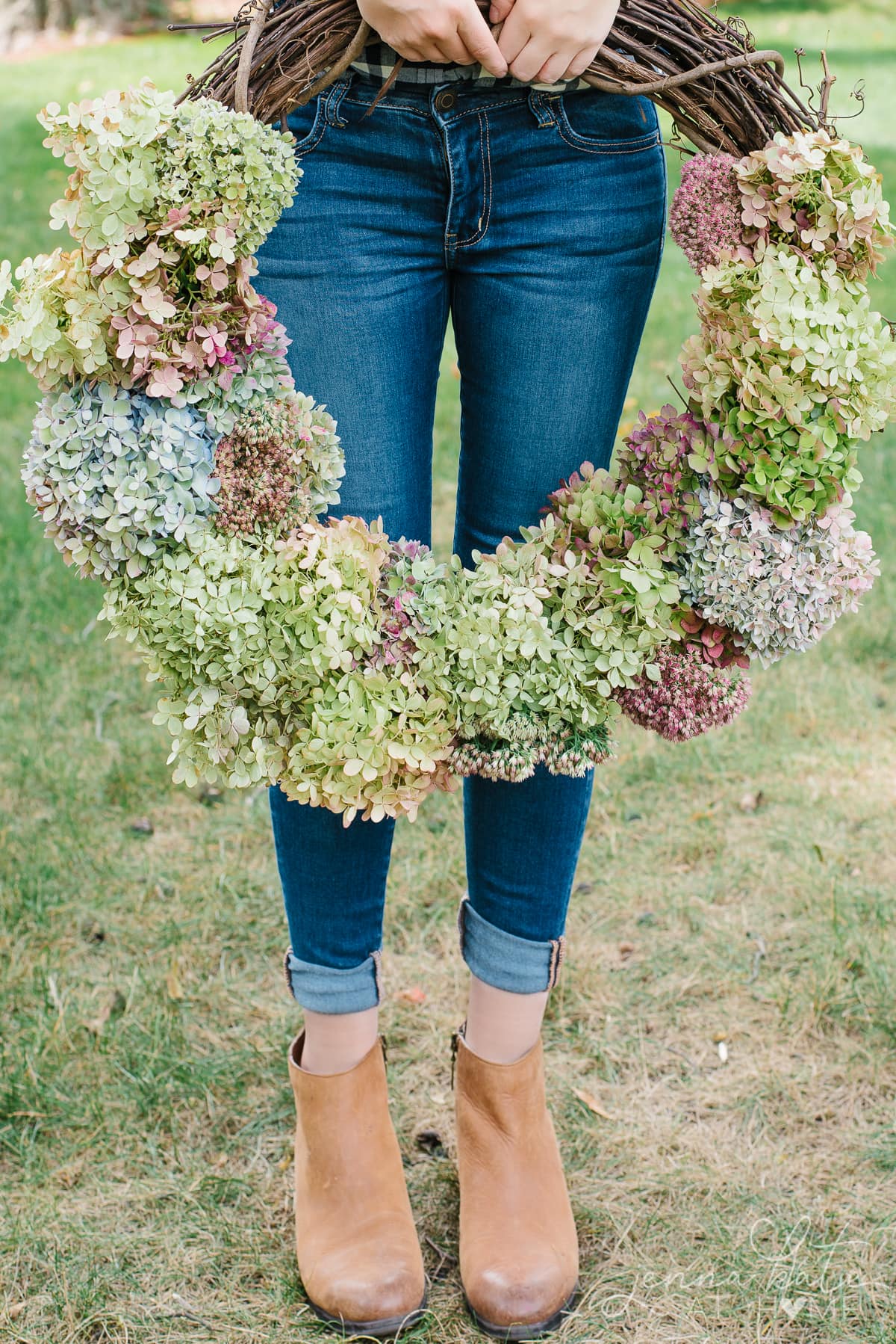 Woman standing holding a diy hydrangea flower wreath.