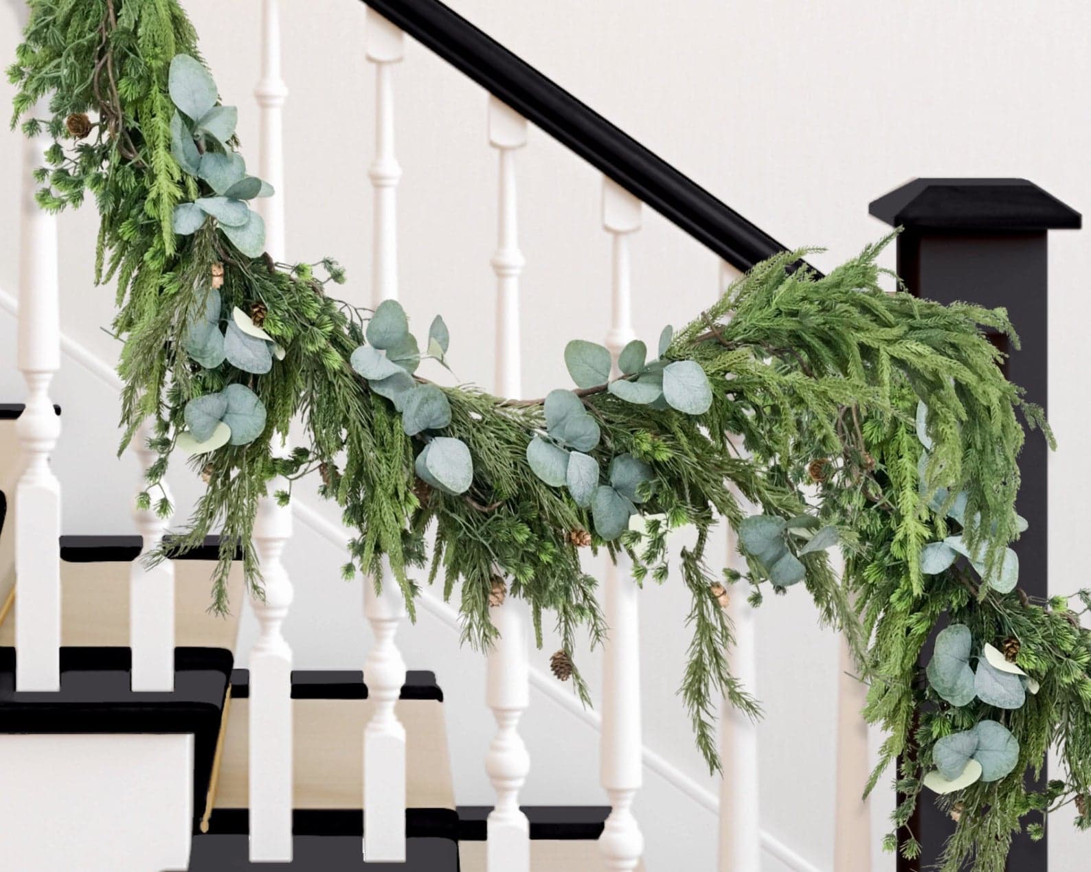 Pine and eucalyptus garland hanging from stair railing