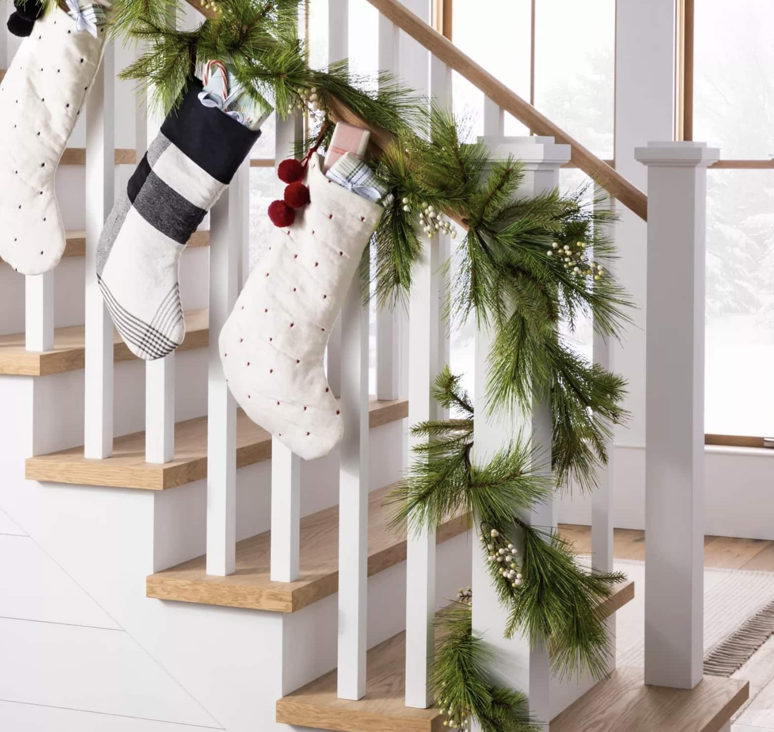 pine needle Christmas garland on a staircase with Christmas stockings