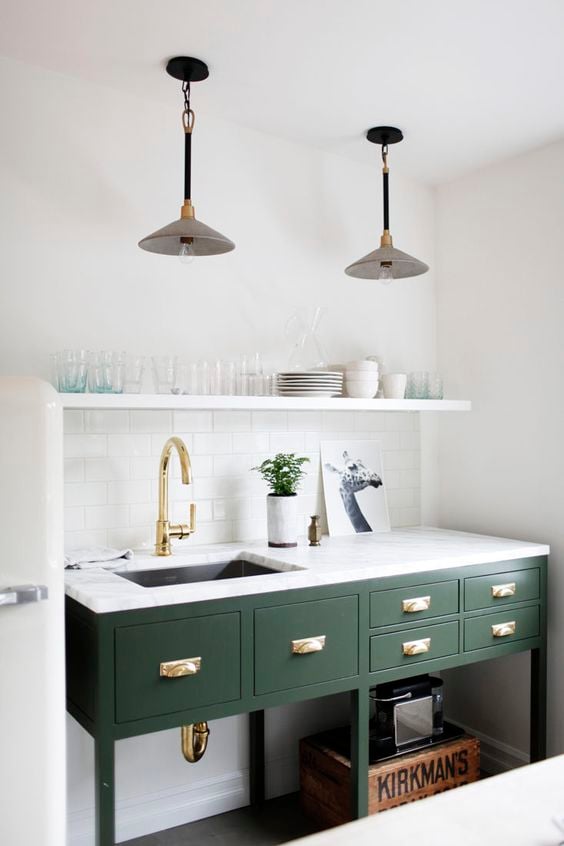 Kitchen island painted green shiny with brass hardware and faucet