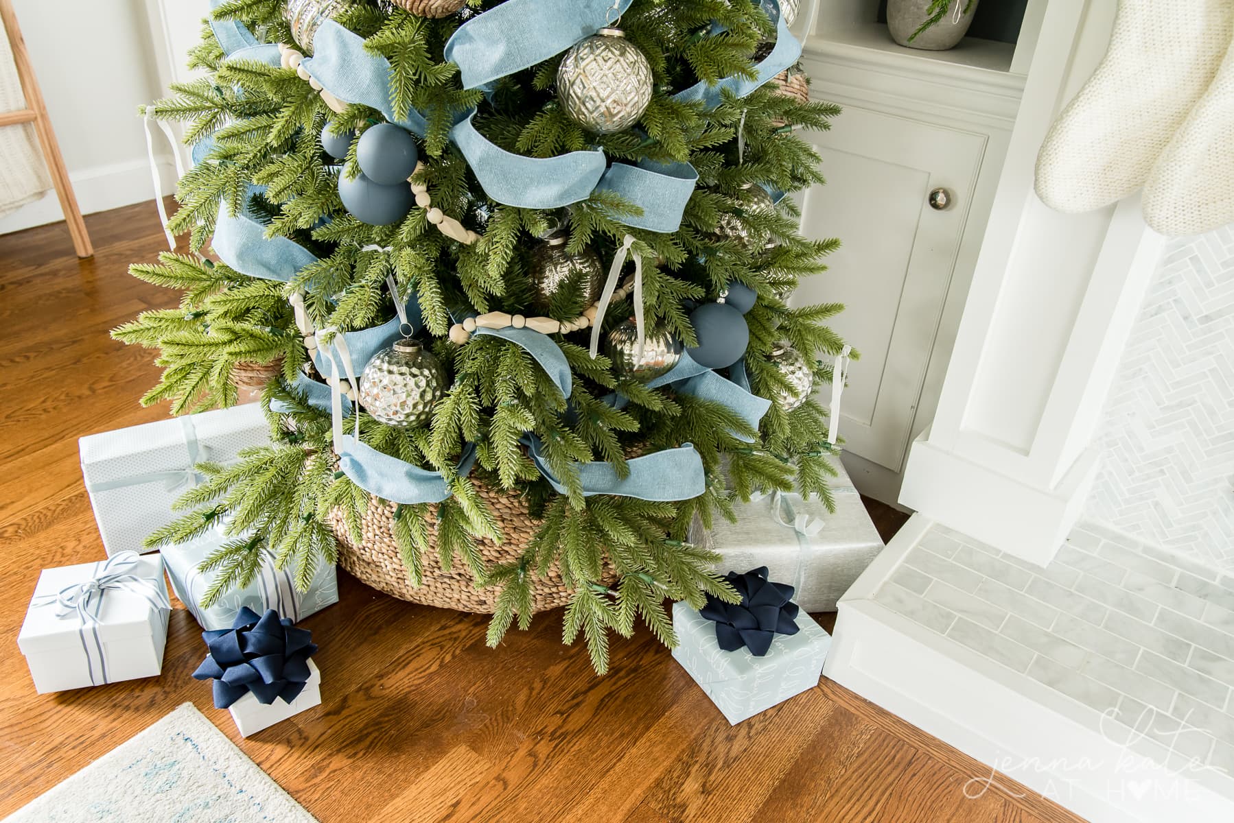 Presents wrapped under the Christmas tree with blue bows