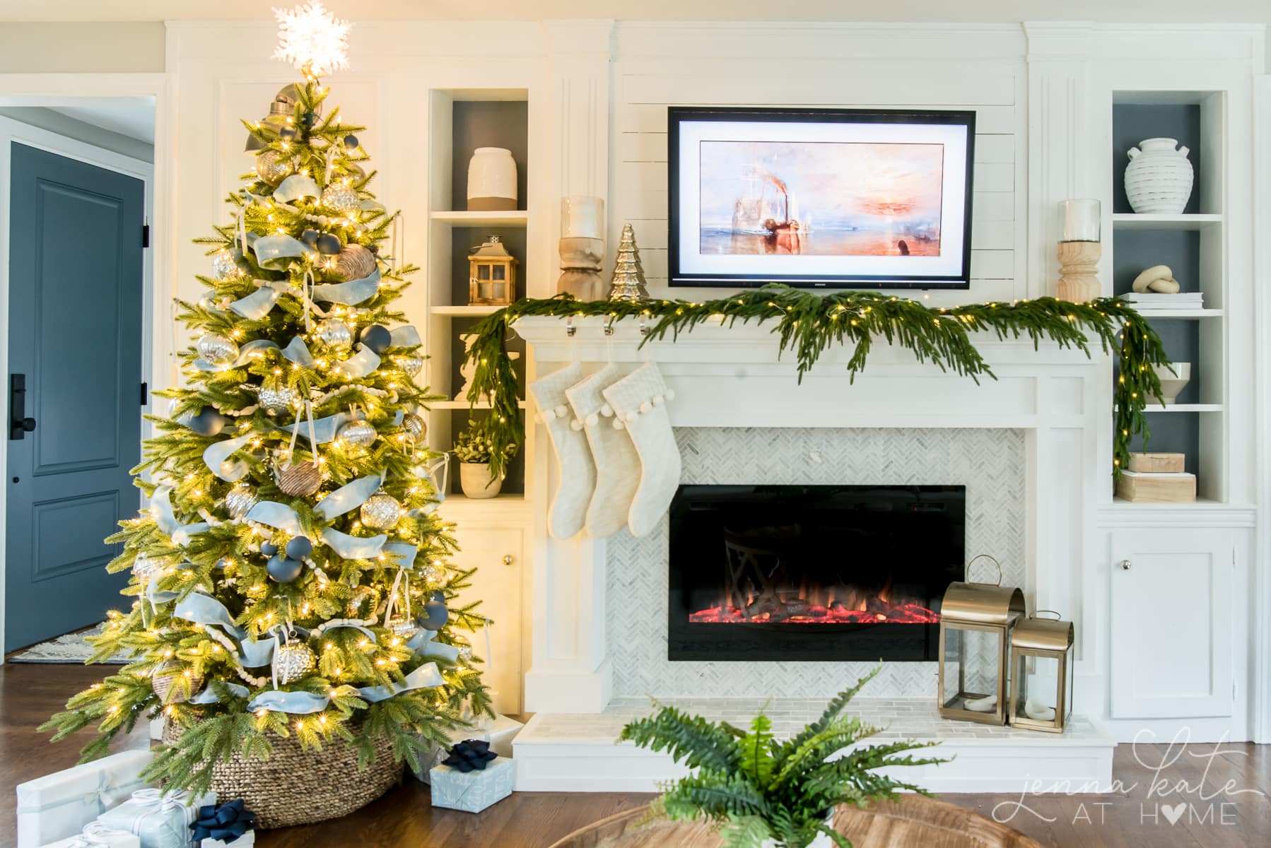 Christmas tree with blue ornaments and ribbon in living room