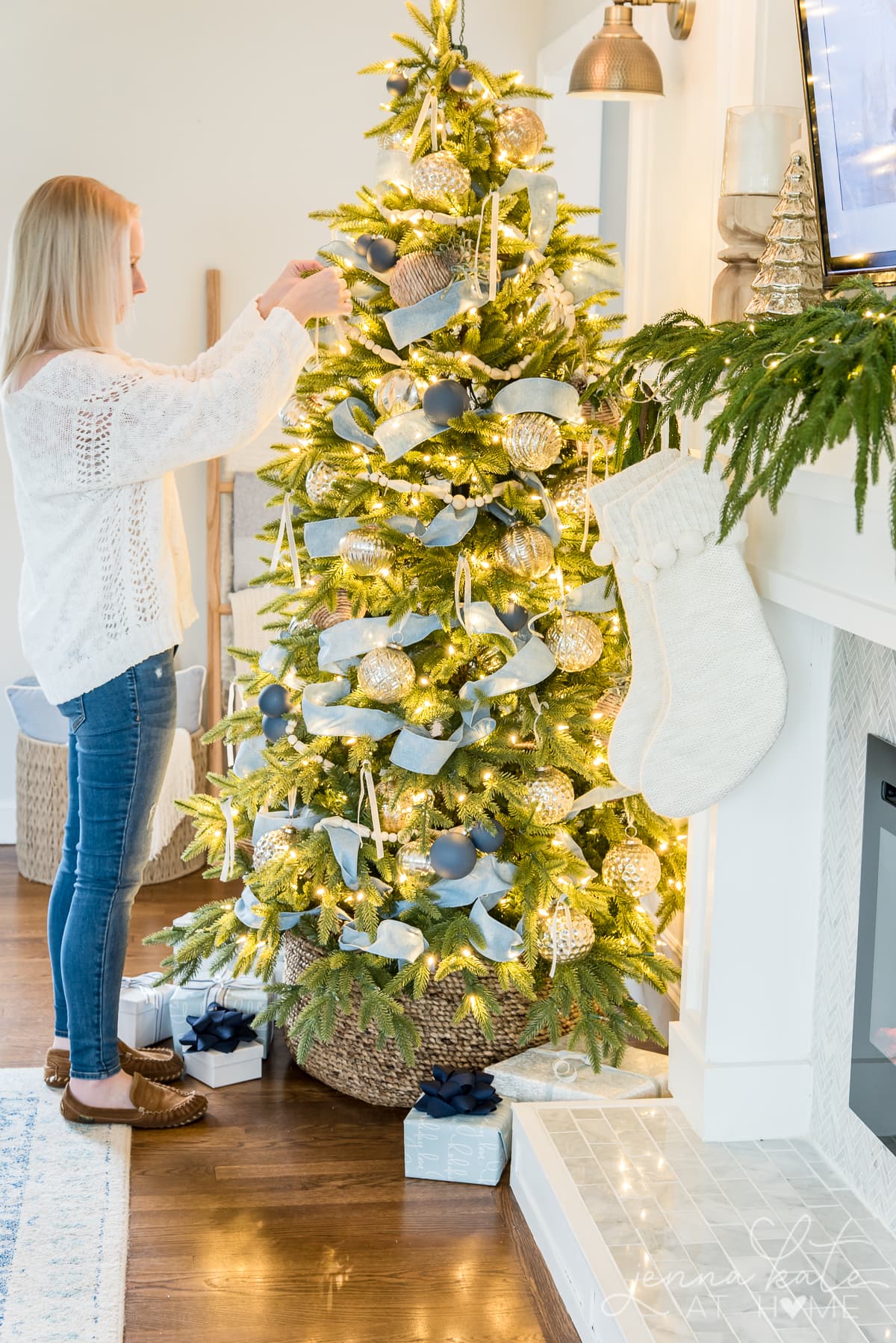 A person adding ribbon to a Christmas tree