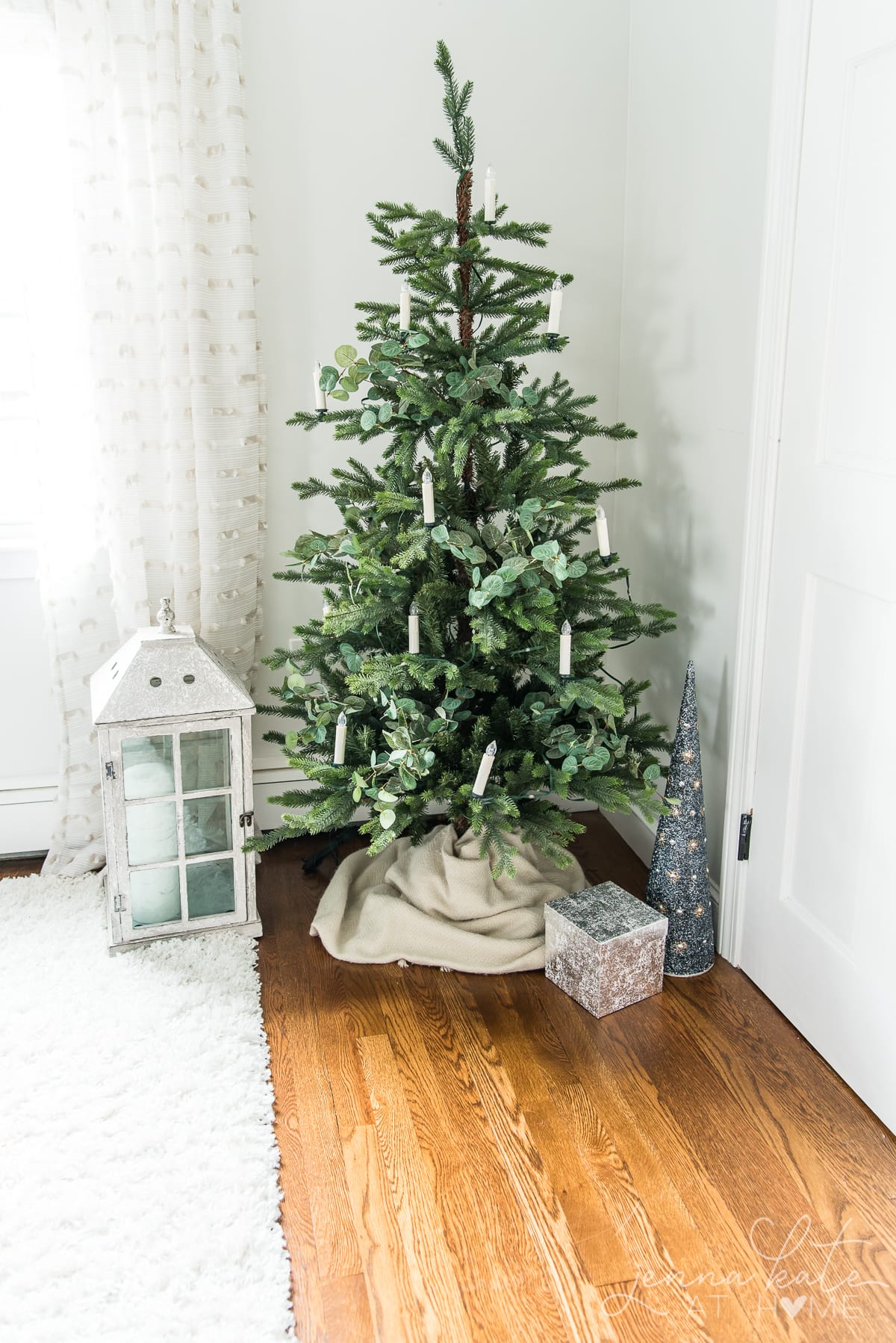 Small Christmas tree with candle lights and eucalytpus