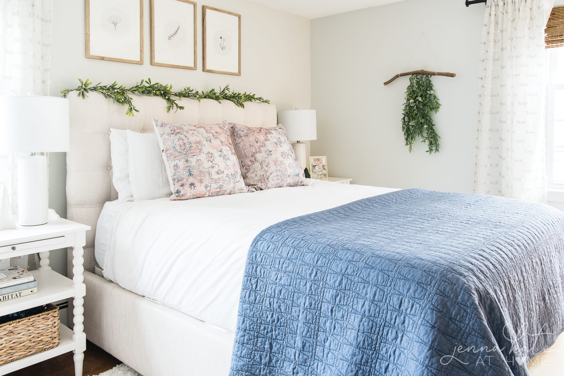 bed with Christmas garland draped over the headboard 