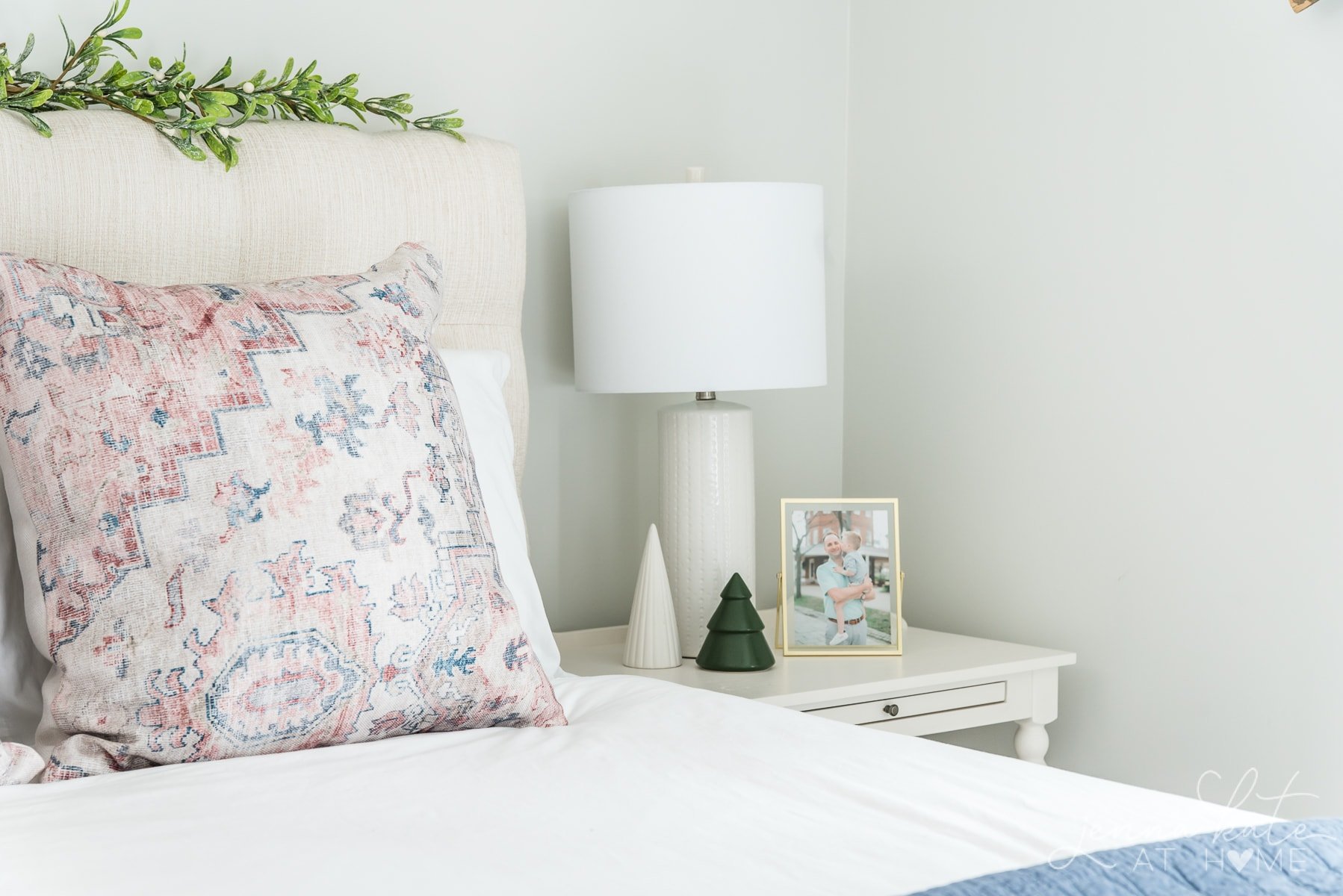 Two small ceramic Christmas trees on a nightstand